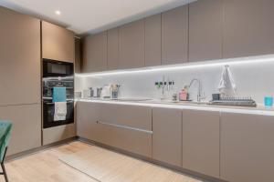 kuchnia z białymi szafkami i zlewem w obiekcie Elegant & Serene 2BD Flat wRoof Terrace Hoxton! w Londynie