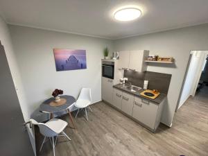 uma pequena cozinha com mesa e cadeiras e um balcão em B&K Immobilien GbR em Tangermünde