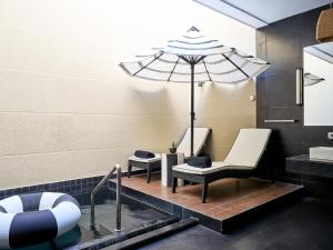 a bathroom with two chairs and an umbrella at Sun Siyam Pasikudah in Pasikuda