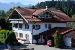 a large white house with a red roof at Ferienwohnung Lichtblick in Rieden am Forggensee