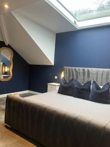 a bedroom with a large bed with a blue wall at terfyn hall holiday apartment 3 stargazer in Prestatyn