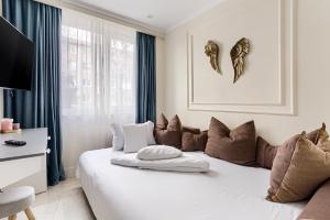 a bedroom with a large white bed with brown pillows at Sika DeLuxe Apartment in Arad