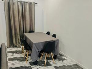 una mesa con sillas negras y un mantel gris en Les 9 Plurielles T 2 KPALIME KOUMA KONDA en Kpalimé