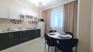 uma cozinha com mesa e cadeiras num quarto em 27 1 комн кв с кондиционером возле Байтерка на 4х человек em Astana