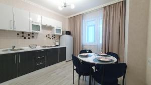 a kitchen with a table and chairs in a room at 27 1 комн кв с кондиционером возле Байтерка на 4х человек in Astana