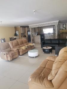 a large living room with couches and a fireplace at Phakathi Lifestyle Village Umnini in Amanzimtoti
