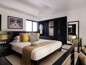 a bedroom with a large bed with yellow pillows at Sun Siyam Pasikudah in Pasikuda