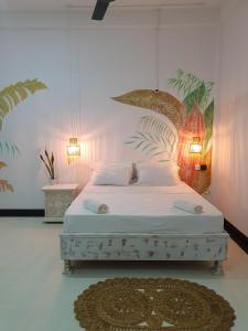 um quarto com uma cama branca e um tapete em GypSea Madiha em Madihe East