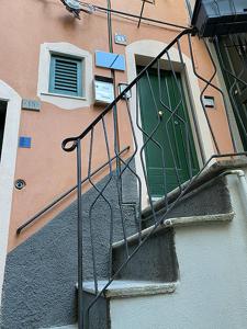 um edifício com uma porta verde e uma varanda em La Bloo di Vernazza - Sea View - AC&WiFi - Vernazzarentals em Vernazza