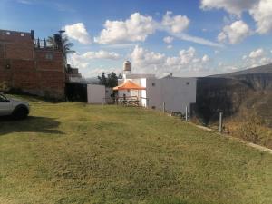 einen grasbewachsenen Hügel mit einem Gebäude mit orangefarbenem Regenschirm in der Unterkunft Villa Campestre con vista in Guadalajara