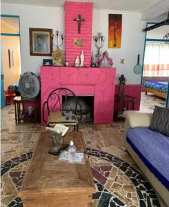 ein Wohnzimmer mit einem rosa Kamin und einem Sofa in der Unterkunft Grutas Tolantongo enixmiquilpan Casamuygde 10camas in Ixmiquilpan
