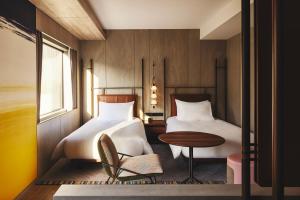 大阪市にあるvoco大阪セントラルのベッドルーム1室(ベッド2台、テーブル、椅子付)