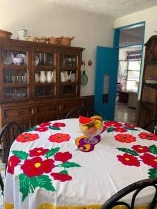 einen Tisch mit einem geblümten Tischtuch mit einer Schüssel darauf in der Unterkunft Grutas Tolantongo enixmiquilpan Casamuygde 10camas in Ixmiquilpan