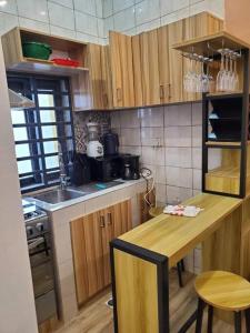 a kitchen with wooden cabinets and a table and a sink at Les 9 Plurielles : Studio 1 KPALIME KOUMA KONDA in Palimé