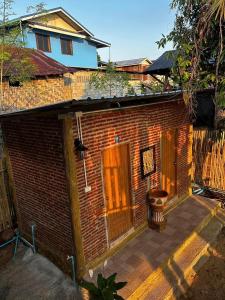 a brick building with a door and a toilet at พาราไดซ์รีสอร์ต สังขละบุรี Paradise Resort at Sangkhlaburi in Sangkhla Buri