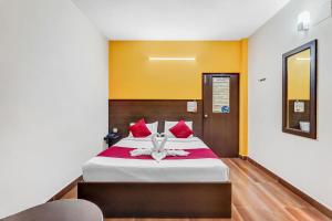 1 dormitorio con 1 cama grande con almohadas rojas en Season 4 Residences -Thiruvanmiyur Near Tidel park Apollo Proton cancer center and IIT Madras Research Park en Chennai