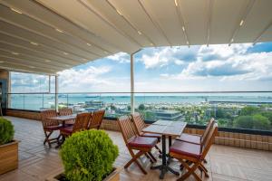 uma varanda com mesas e cadeiras e vista para o oceano em The Time Hotel Marina em Istambul