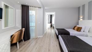 een hotelkamer met 2 bedden en een bureau bij Motto Premium Hotel&Spa in Marmaris