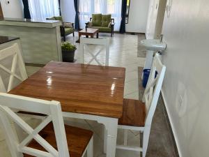 - une table et des chaises en bois dans une chambre avec cuisine dans l'établissement Wembley villla diani beach, à Diani Beach