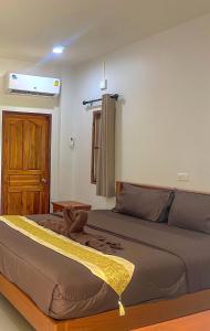 um quarto com uma cama grande e uma porta de madeira em บ้านสวนเปรมณัฐตรา em Ban Song (1)