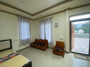 a bedroom with two beds and a large window at Evergreen Home Stay in Āīzawl