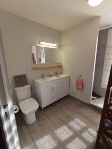 a white bathroom with a toilet and a sink at Ravissante maison sur les hauteurs in Faaa