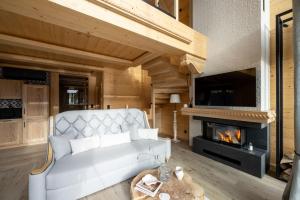 a living room with a couch and a fireplace at Chaletovo Mountain Residences in Zakopane