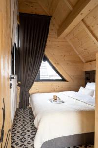 Un dormitorio con una cama grande y una ventana en Chaletovo Mountain Residences, en Zakopane 144 fotos más