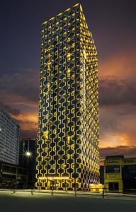 um edifício alto com luzes ao lado em Hotel The Designers Premier Kondae em Seul