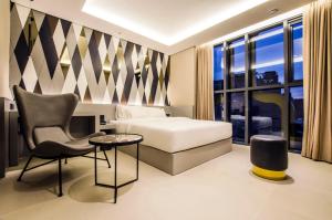 a hotel room with a bed and a chair at Hotel The Designers Premier Kondae in Seoul