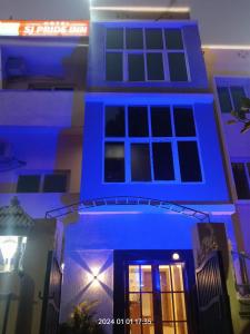 una casa con luci blu sulla parte anteriore di HOTEL SJ PRIDE INN a Bhubaneshwar