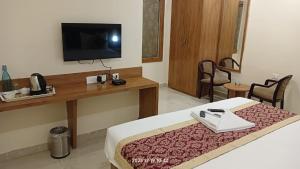 una camera d'albergo con letto e televisore a parete di HOTEL SJ PRIDE INN a Bhubaneshwar