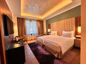 a hotel room with two beds and a desk at Vivanta Tawang in Tawang