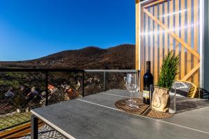 una mesa con una botella de vino y una copa en Moose & Reindeer Cabin Chalets With A Panoramic View - Happy Rentals, en Hosszúhétény-Szőlőhegy