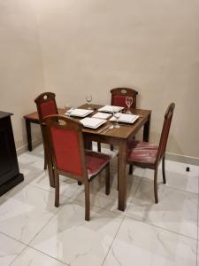 a wooden table and chairs with wine glasses on it at شقق نبراس الفارس للشقق المخدومة - اقتصادي in Tabuk +7 photos
