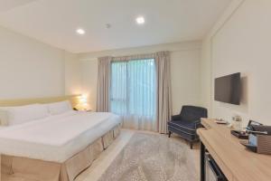 a hotel room with a large bed and a chair at Changi Cove in Singapore