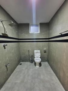 La salle de bains est pourvue de toilettes et d'une fenêtre. dans l'établissement GypSea Madiha, à Madihe East