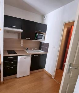 a small kitchen with a sink and a microwave at Appartement AX - proche départ rando - piscine - balcon - Le blancflocon in Ax-les-Thermes