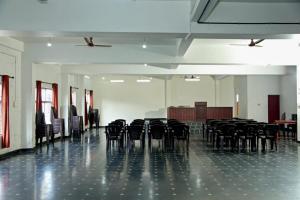una habitación vacía con sillas negras y una mesa en KTM PRINCEINN en Kalpatta