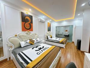 two beds in a room with two chairs at Sky Star 2 Hotel in Can Tho