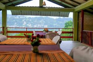 een veranda met tafels en stoelen en uitzicht bij Deer Point Hotel Kandy in Kandy