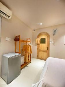 1 dormitorio con 1 cama y puerta de madera en VV House Quy Nhon Homestay, en Quy Nhon