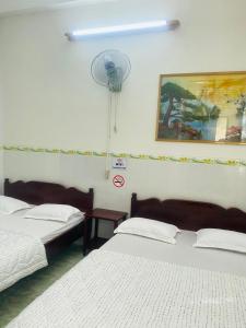 Camera con 2 letti e un ventilatore a muro di Thanh Binh Hotel a Buôn Ma Thuột