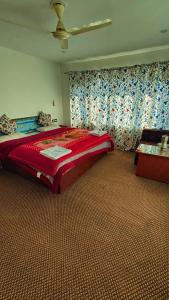 a bedroom with a large red bed in a room at Tip Top Pahalgam in Pahalgām