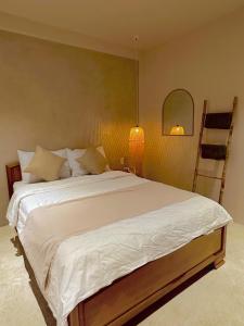 クイニョンにあるVV House Quy Nhon Homestayのベッドルーム(ランプ付きの白い大型ベッド1台付)