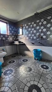 a bathroom with a blue toilet and a sink at Tip Top Pahalgam in Pahalgām