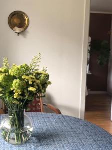 un vaso di fiori gialli seduto su un tavolo di Cosy aparment in Bergen a Bergen