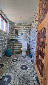a bathroom with a toilet and a tiled floor at Tip Top Pahalgam in Pahalgām