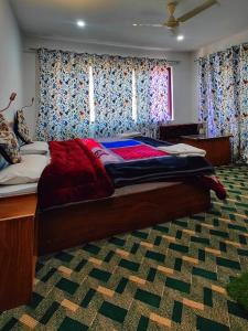 - un grand lit dans une chambre avec des rideaux dans l'établissement Tip Top Pahalgam, à Pahalgām