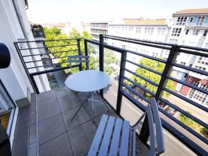 einen Balkon mit einem weißen Tisch und Stühlen in der Unterkunft SC 7 Cozy Family & Business in Berlin
